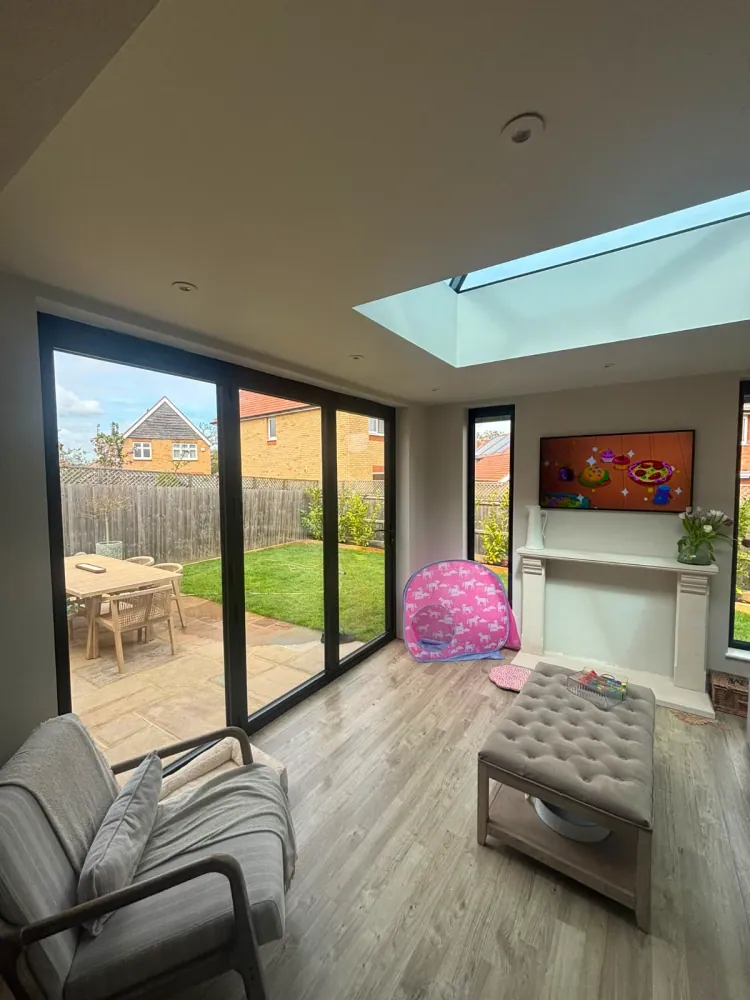 Bright open-plan garden room with a flat glass rooflight and anthracite sliding doors onto the garden
