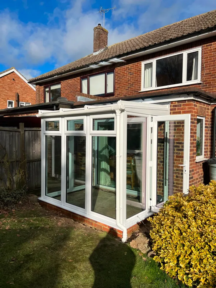 White uPVC conservatory with bifold doors on a red-brick home
