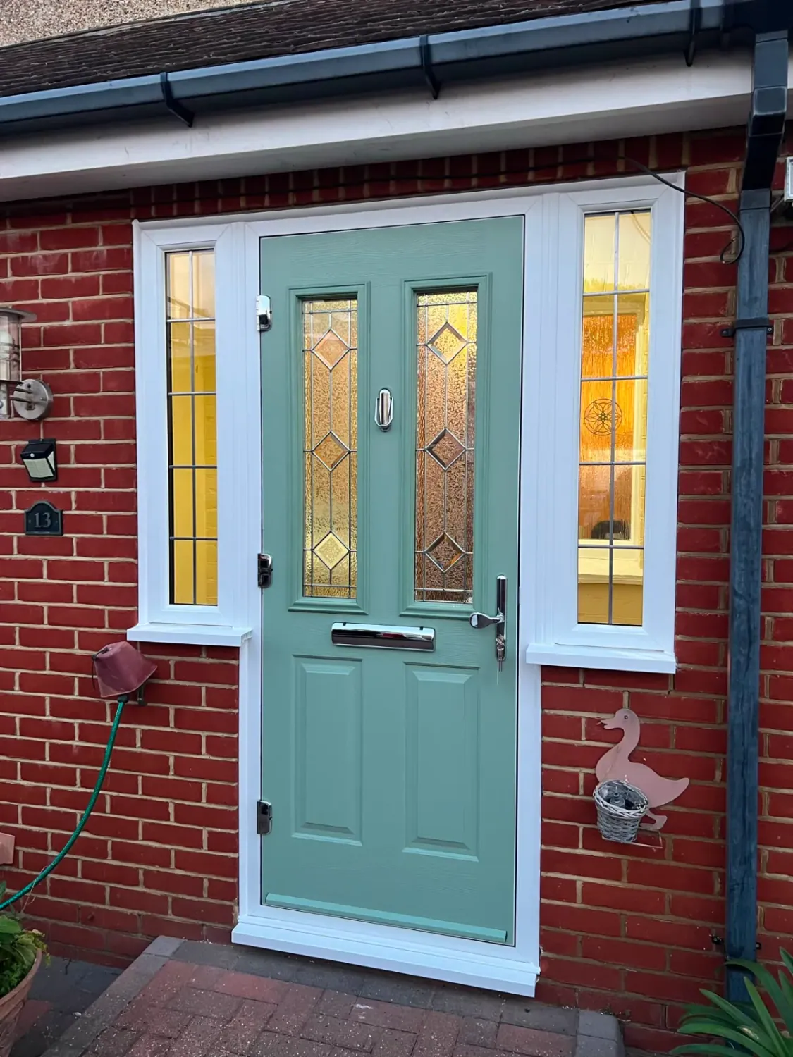 Anthracite composite front door with a glazed side panel and chrome hardware