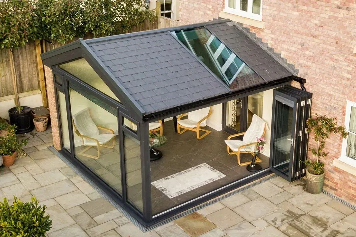 Modern modular extension with a solid slate roof, glazed walls and bifold doors