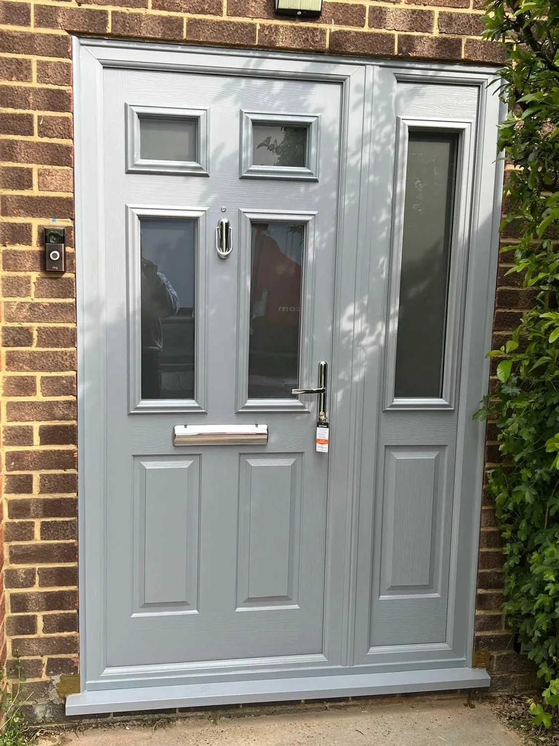 Grey traditional panelled composite front door with glazed side panels