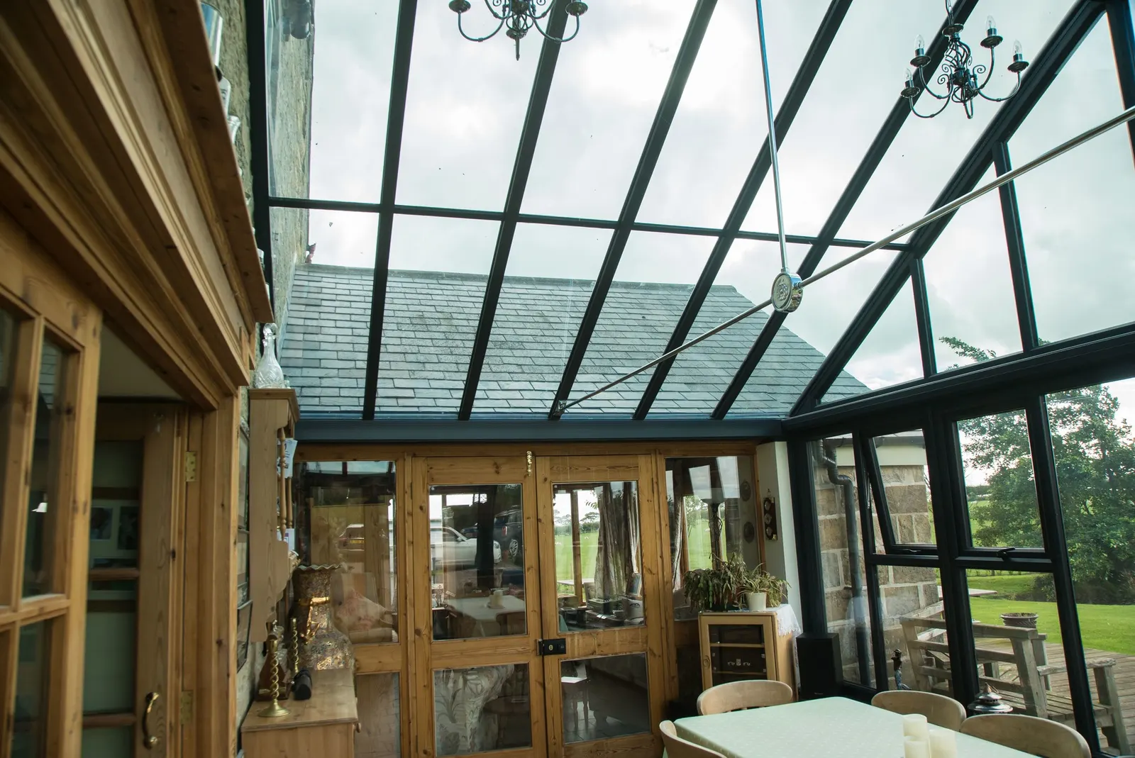 An oak-framed conservatory interior beneath a grey glazed roof