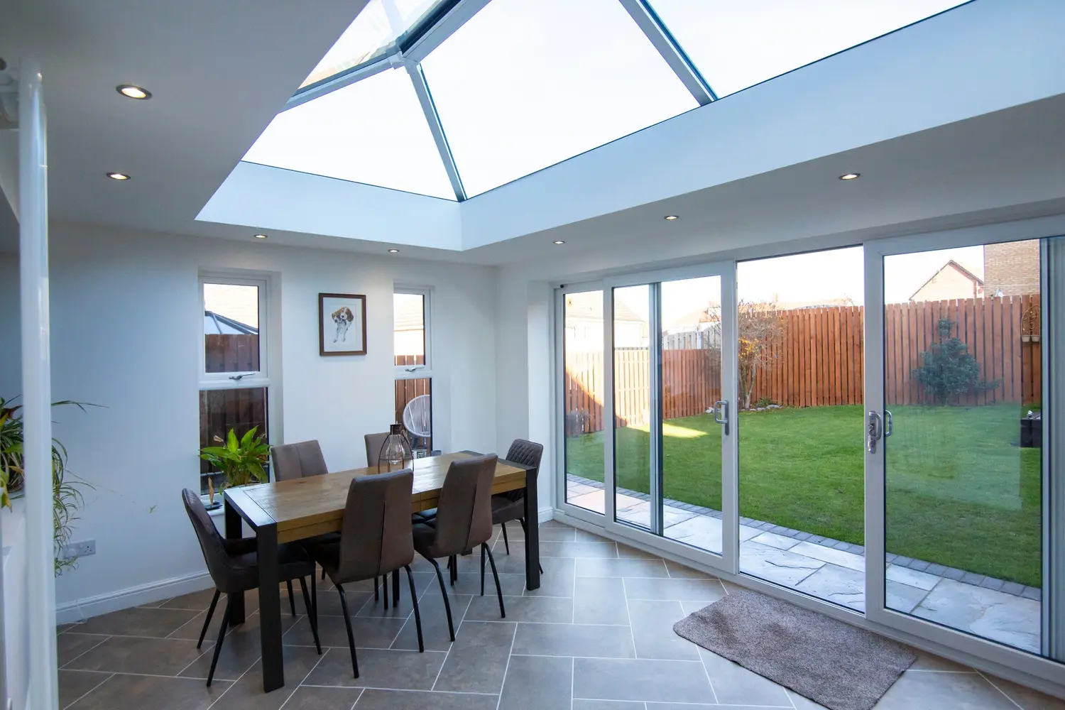 A four-panel white sliding patio door run across a dining room, showing the panel proportions