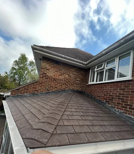 A completed tiled warm roof on a conservatory, seen from above against the brickwork of the house