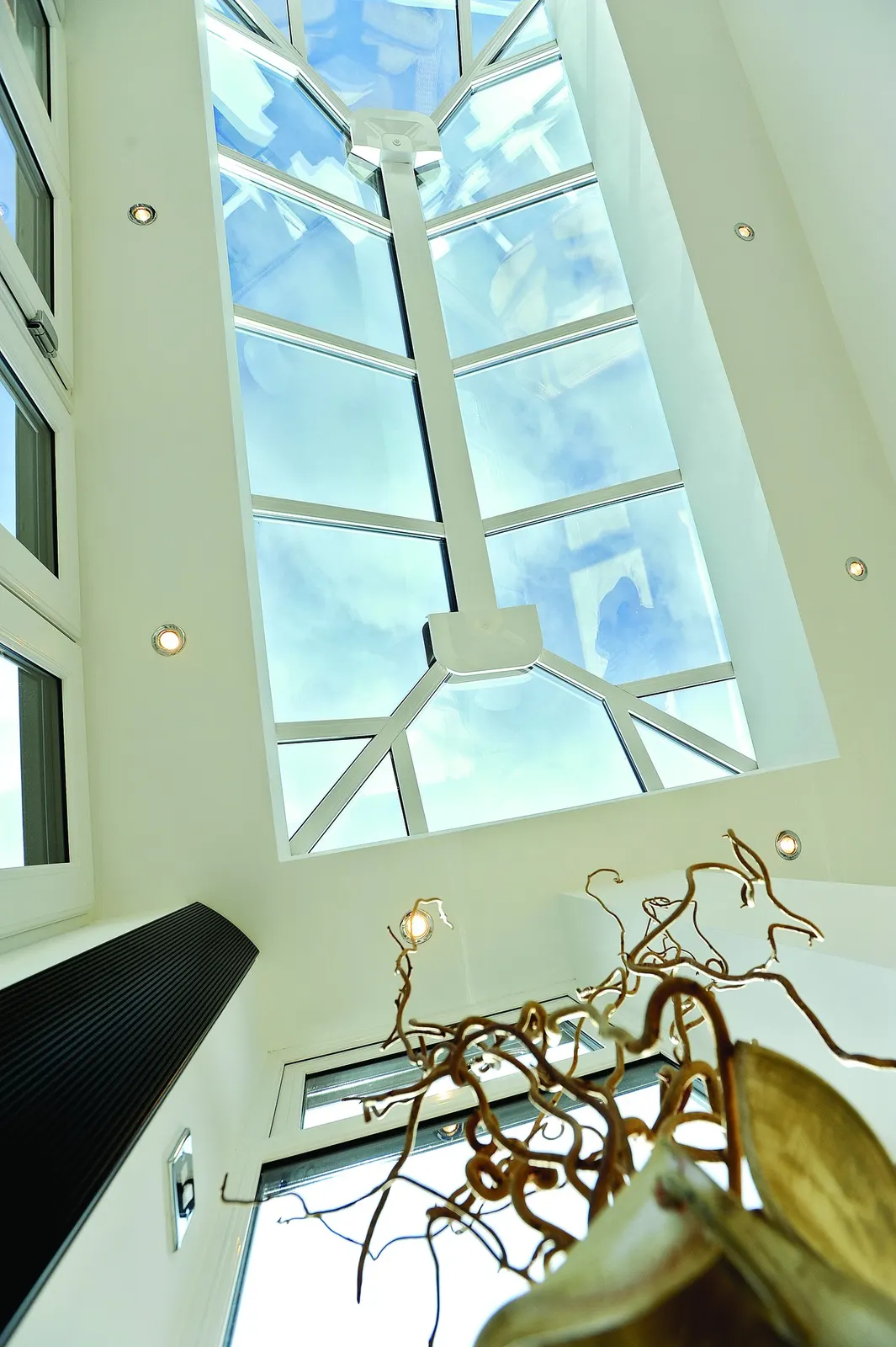 A glazed roof lantern seen from directly below, with recessed downlights around it