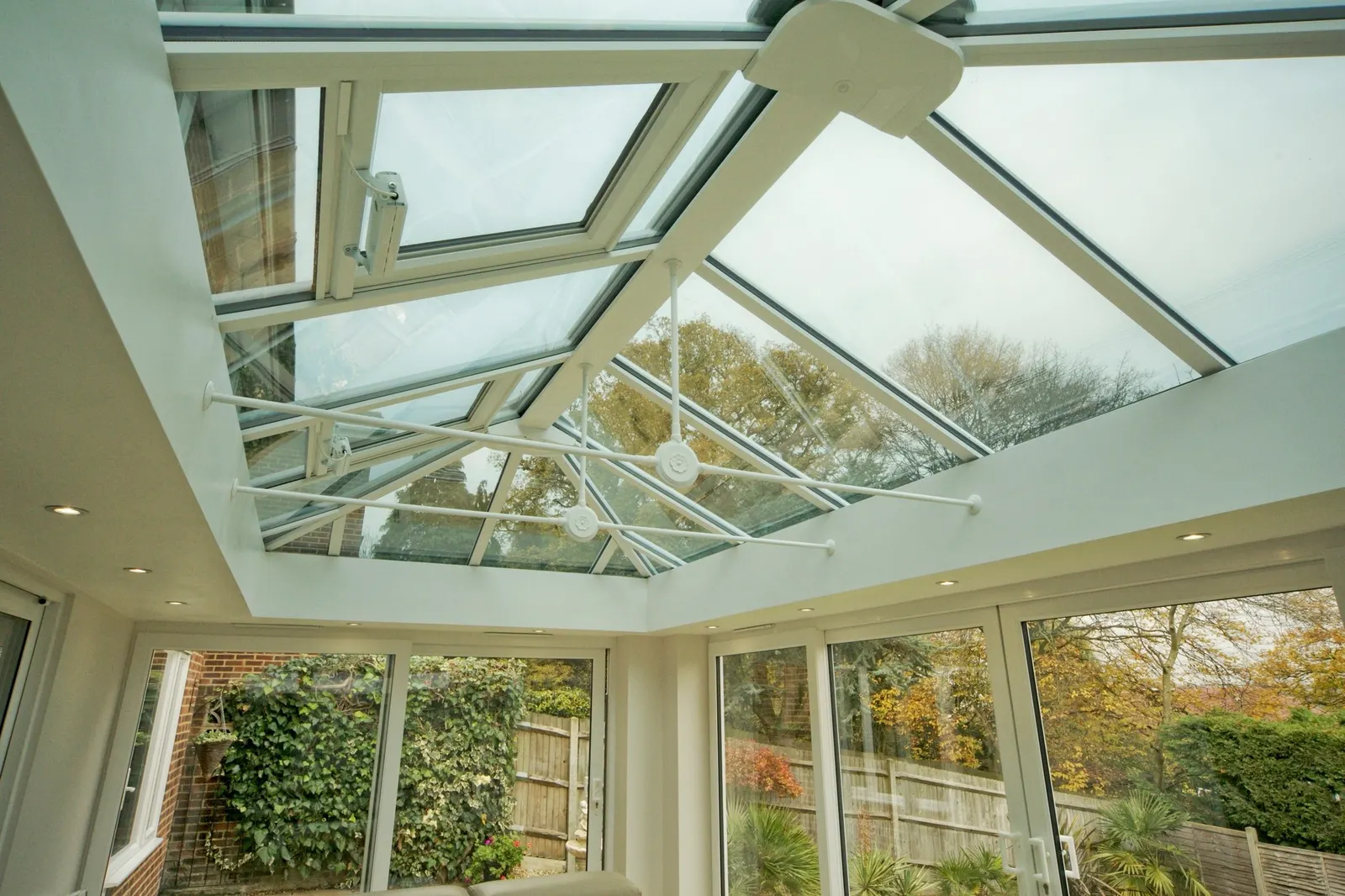 A white glazed roof lantern from inside, over a room with full-height glazing