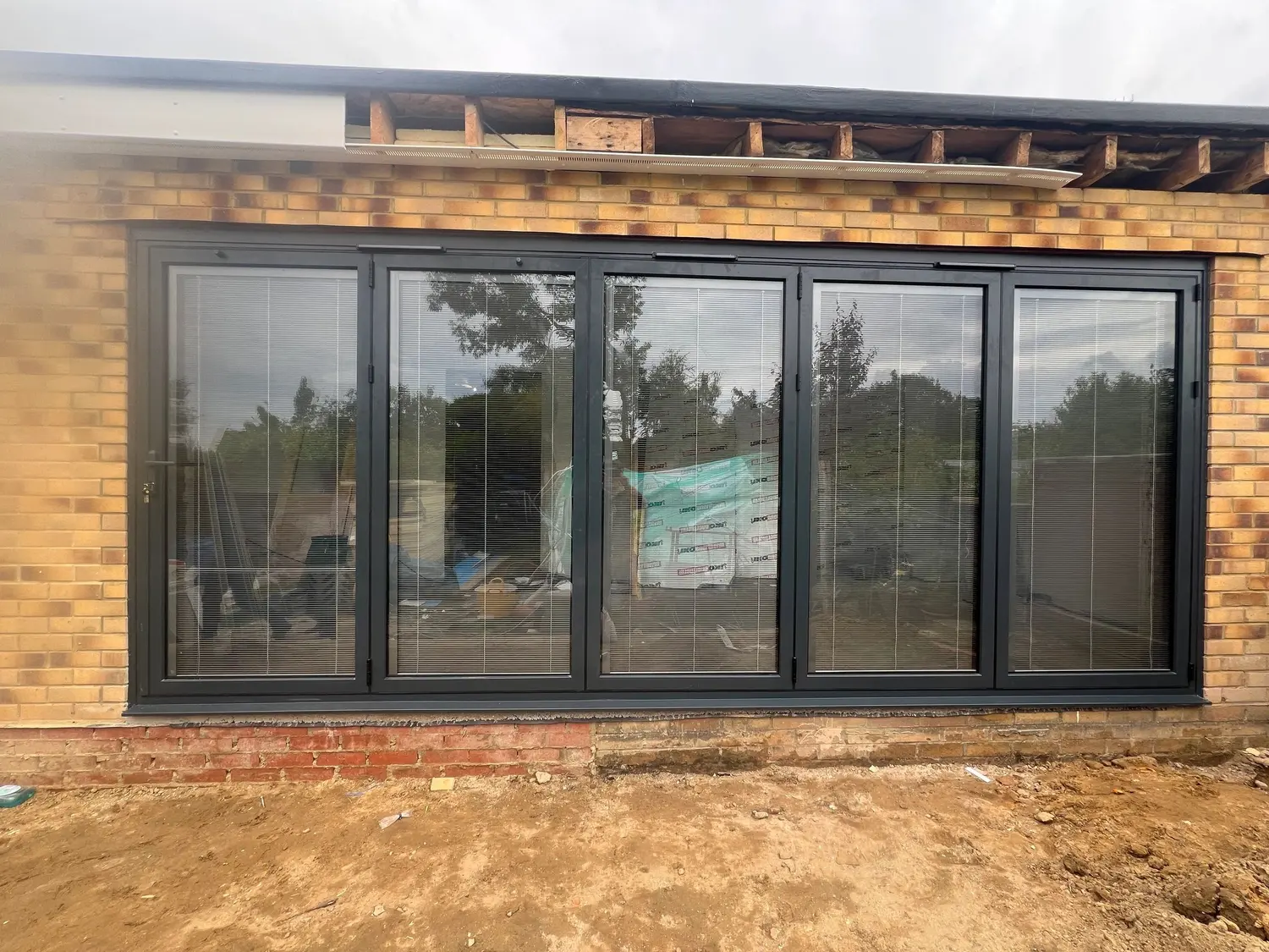 Anthracite aluminium multi-panel doors across the back of a newly built extension