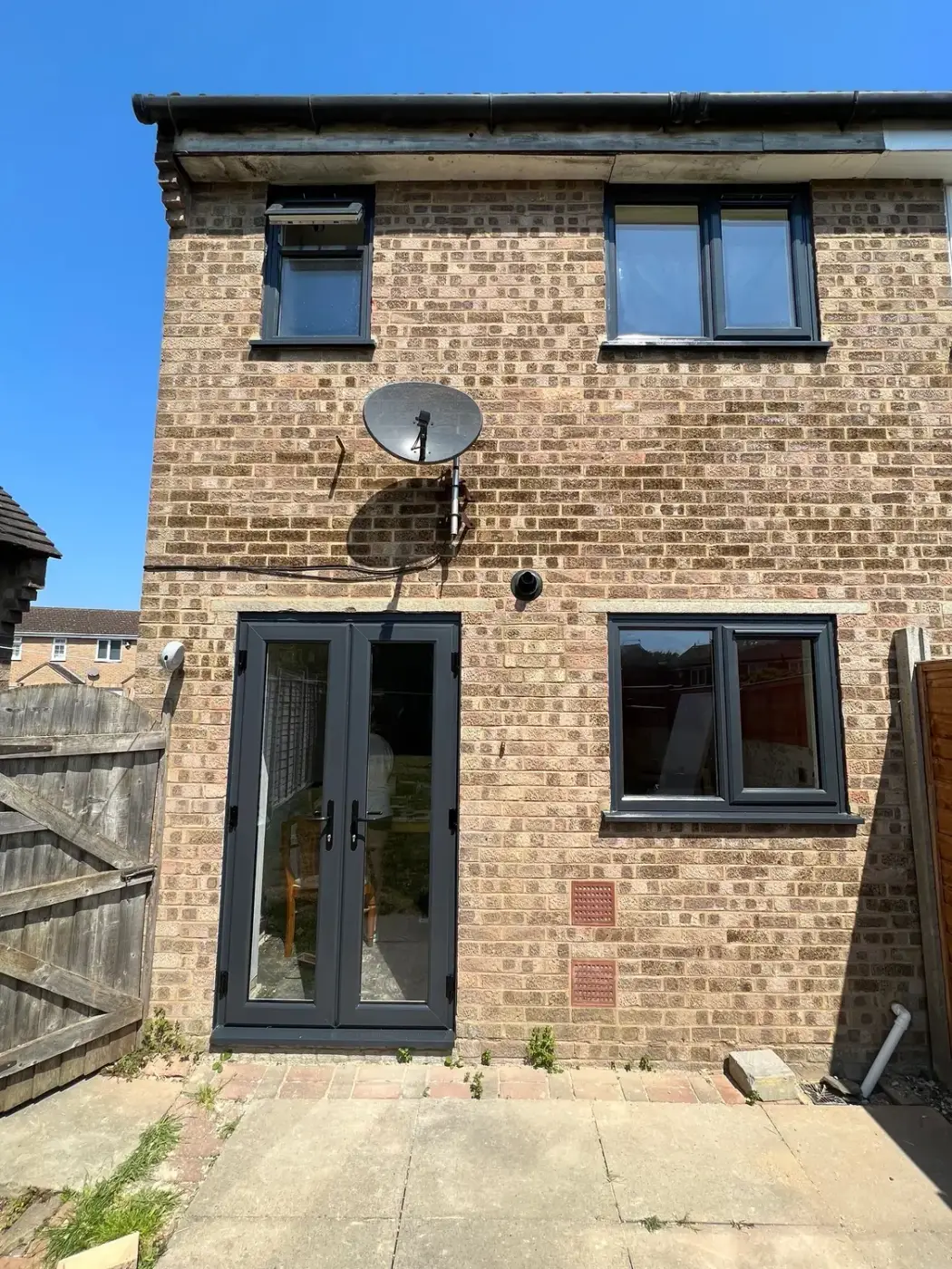 Anthracite French doors and matching windows on a brick house