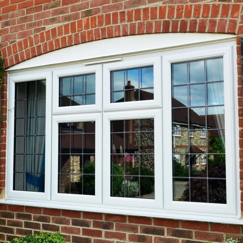 A white UPVC bay window with leaded top lights, on a red brick house
